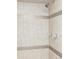 Modern bathroom shower featuring neutral tiling with decorative mosaic stripes at 2895 S Sherman St, Englewood, CO 80113