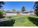 Large backyard with a lush green lawn and detached garage at 903 Poplar St, Denver, CO 80220