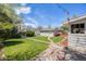 Landscaped backyard featuring a lush green lawn, stone walkway and mature trees at 903 Poplar St, Denver, CO 80220