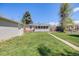 Expansive backyard with lush green lawn, mature trees, and detached garage at 903 Poplar St, Denver, CO 80220