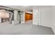 Unfinished basement with painted floor and utility connections with view to finished room at 903 Poplar St, Denver, CO 80220