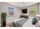 Bedroom features hardwood floors, two bright windows, and modern furnishings at 903 Poplar St, Denver, CO 80220