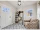 Inviting home entryway featuring patterned tile floor, coat rack, and comfortable armchair at 903 Poplar St, Denver, CO 80220