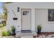 Close-up of a home's front door and porch with decorative plants and modern fixtures at 903 Poplar St, Denver, CO 80220