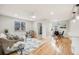 Open-concept living area with hardwood floors and modern furnishings flowing into dining space at 903 Poplar St, Denver, CO 80220
