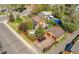 Aerial view of a charming property with a fenced backyard, detached garage, patio, and lush landscaping at 998 S Leyden St, Denver, CO 80224