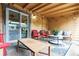 View of the covered back porch with chairs, coffee table, and a sun decoration on the wall at 998 S Leyden St, Denver, CO 80224