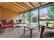 View of the covered back porch with chairs, table and an exterior view of the backyard at 998 S Leyden St, Denver, CO 80224