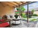 View of the covered back porch with chairs, table and an exterior view of the backyard at 998 S Leyden St, Denver, CO 80224