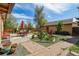 Charming backyard featuring a brick patio, lush landscaping, and outdoor dining area with umbrella-covered table at 998 S Leyden St, Denver, CO 80224