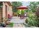 Charming backyard with a wooden deck featuring an umbrella-covered dining area and vibrant plantings at 998 S Leyden St, Denver, CO 80224