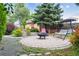 The backyard is an inviting space with a brick patio, swing, fire pit, and colorful outdoor decor at 998 S Leyden St, Denver, CO 80224