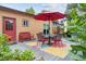 Backyard deck with table, chairs, a red umbrella and lush greenery at 998 S Leyden St, Denver, CO 80224