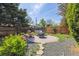 Relaxing backyard features a brick patio with fire pit, swing, privacy fence, and mature trees at 998 S Leyden St, Denver, CO 80224