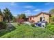 Expansive backyard with lush greenery, covered patio, dining area, and well-maintained landscaping at 998 S Leyden St, Denver, CO 80224