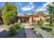 Inviting backyard with brick pathway, mature trees, covered patio, and outdoor seating, perfect for entertaining at 998 S Leyden St, Denver, CO 80224