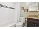 Bathroom with white tiled shower/tub and dark vanity at 998 S Leyden St, Denver, CO 80224