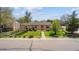 Charming single-story home featuring mature trees, landscaped yard and inviting walkway to front door at 998 S Leyden St, Denver, CO 80224