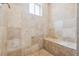 The shower features light brown stone tiles, a small window, and a built in bench at 998 S Leyden St, Denver, CO 80224