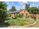 Single-story home with lush green yard, mature trees, and privacy fence at 998 S Leyden St, Denver, CO 80224