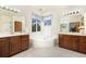 Bathroom featuring double sinks, a soaking tub, and updated fixtures at 1831 Ashford Cir, Longmont, CO 80504