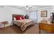 Cozy bedroom featuring a bed with a wood headboard, ceiling fan, and ample natural light at 1831 Ashford Cir, Longmont, CO 80504