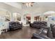 Spacious living room features three leather couches, hardwood floors and archway views to kitchen at 1831 Ashford Cir, Longmont, CO 80504