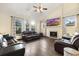 Bright living room with a vaulted ceiling, fireplace, hardwood floors, and comfortable leather furniture at 1831 Ashford Cir, Longmont, CO 80504