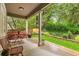 Covered patio area with outdoor seating, overlooking a landscaped yard and mature trees at 1831 Ashford Cir, Longmont, CO 80504