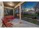 Relax on this covered patio with red outdoor furniture and a view of the large backyard at 1831 Ashford Cir, Longmont, CO 80504