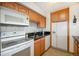 Galley kitchen with wood cabinets, granite counters, and white appliances at 1020 15Th St # 34L, Denver, CO 80202