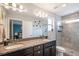 Bathroom with double sinks, granite countertops, walk-in shower and neutral tiling at 17996 E 54Th Ave, Denver, CO 80249