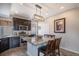 Bright kitchen with granite island, dark cabinets, stainless steel appliances, and pendant lighting at 17996 E 54Th Ave, Denver, CO 80249