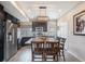 Stylish kitchen featuring dark cabinets, stainless steel appliances, and a granite-topped island with bar seating at 17996 E 54Th Ave, Denver, CO 80249