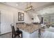 Kitchen island with bar seating flows into a cozy living area, offering a modern open-concept design at 17996 E 54Th Ave, Denver, CO 80249