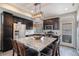 Stylish kitchen with dark cabinetry, stainless steel appliances, a granite island and eat-in bar at 17996 E 54Th Ave, Denver, CO 80249