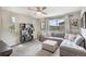 Inviting living room featuring a comfortable sectional sofa, modern shelving, and large windows at 17996 E 54Th Ave, Denver, CO 80249