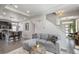 Open-concept living space with a staircase, comfortable seating, and access to the kitchen at 17996 E 54Th Ave, Denver, CO 80249