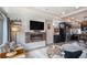 Cozy living room featuring a fireplace, TV, comfortable seating, and modern décor at 17996 E 54Th Ave, Denver, CO 80249