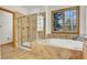 Bright bathroom featuring a soaking tub and separate glass shower enclosure at 1294 Red Lodge Dr, Evergreen, CO 80439