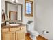 Bathroom featuring a wood vanity, decorative mirror, and natural light from the window at 1294 Red Lodge Dr, Evergreen, CO 80439