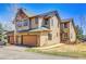 Tan two-story townhome featuring three-car garage and well maintained lawn at 1294 Red Lodge Dr, Evergreen, CO 80439