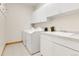 Well-lit laundry room featuring white cabinets, sink, and washer/dryer at 1294 Red Lodge Dr, Evergreen, CO 80439