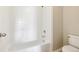 This bathroom features a white tiled tub, chrome fixtures, and a bright neutral wall color at 10480 Truckee St # B, Commerce City, CO 80022