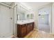 Bright bathroom features a double sink vanity, wood flooring, and a glass-enclosed shower with white tiling at 10480 Truckee St # B, Commerce City, CO 80022