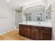 Bathroom with double sinks, wood cabinets, shower, and large mirror at 10480 Truckee St # B, Commerce City, CO 80022