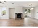 Open living room with a stone fireplace, hardwood floors, and sliding patio door at 10480 Truckee St # B, Commerce City, CO 80022