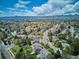 Panoramic aerial shot of a neighborhood nestled among lush trees with mountain views in the distance at 5172 S Cody Ct, Littleton, CO 80123