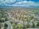 Wide aerial shot showcasing a neighborhood nestled among trees, with mountain views in the distance at 5172 S Cody Ct, Littleton, CO 80123