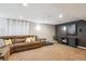 Finished basement with a large brown sectional couch, flat screen tv, and cozy carpet at 5172 S Cody Ct, Littleton, CO 80123